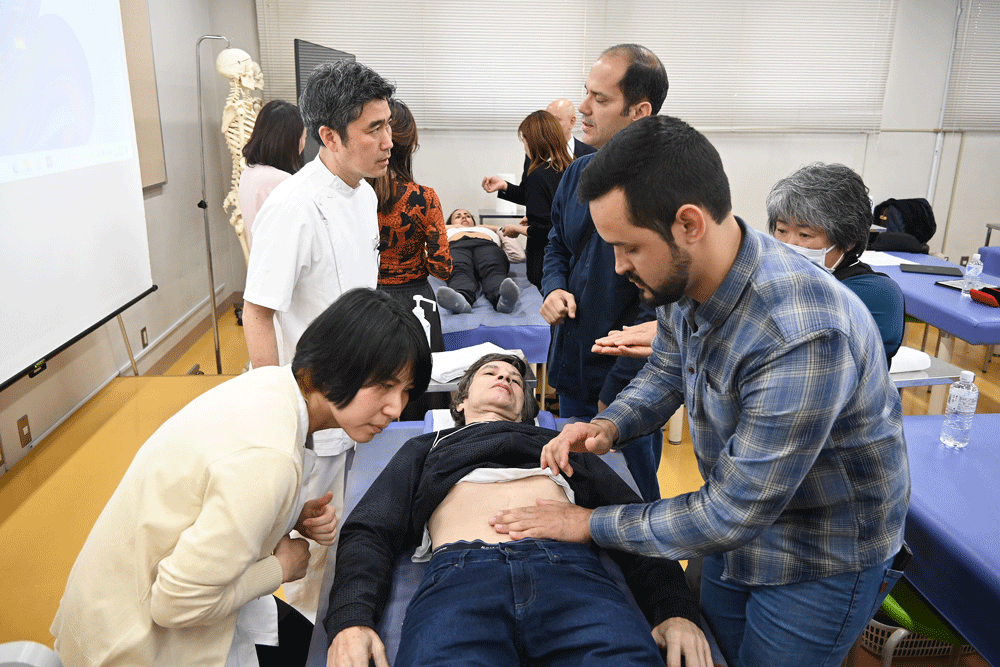 手の当て方、指のはずみ、音の聴き方全てに決まりがある。通訳も間に入り解説を手伝った